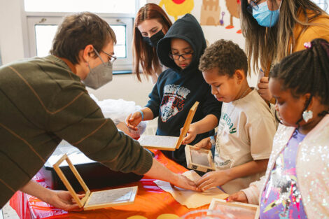Lafayette student guides young elementary students through a paper making activity