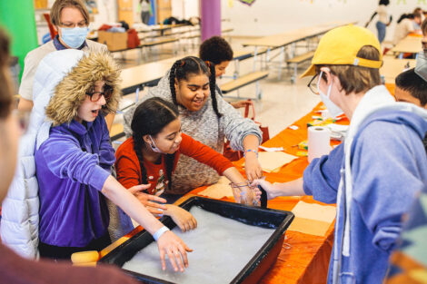 Lafayette student guides young elementary students through a paper making activity