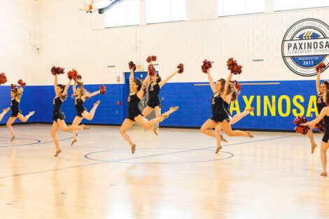 Lafayette dance team perform in black uniforms and red pom-moms in gymnasium