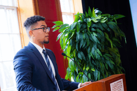 Devin On '22 stands at podium and presents at the 15th scholarship reception.