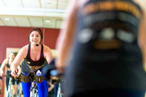 spin instructor leads a class of spin riders