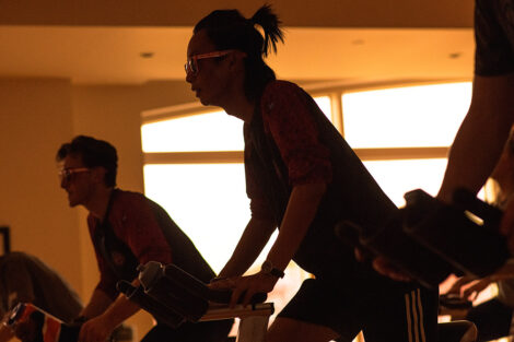 students ride spin bikes