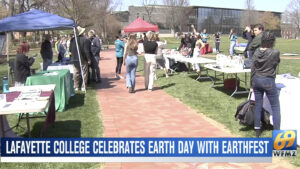 people stand at tables arranged on the Quad for EarthFest