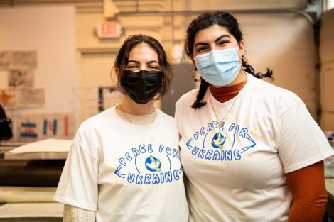 Two students in masks display the shirt