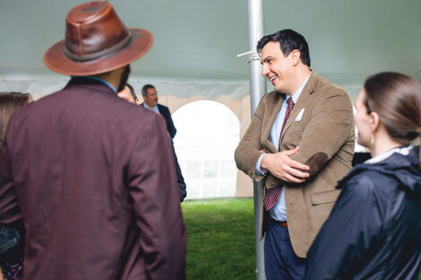 Prof. Andrew Clark talks with other faculty members under a white tent