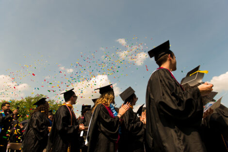 Confetti falls around graduates.
