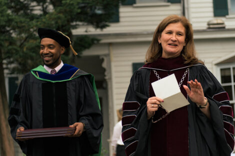 Dean Tim Cox holds three diploma cases, President Nicole Hurd stands beside him and speaks