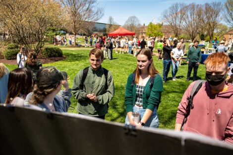 students gather to look at poster session research on the Quad