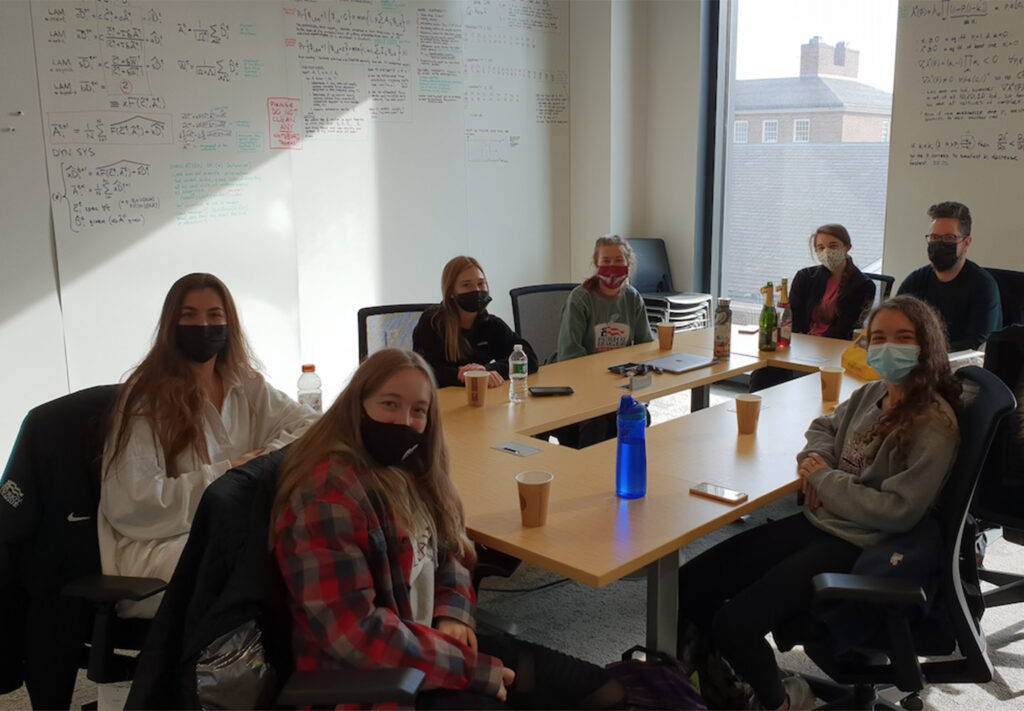 Professor Strömbom, Montana Coleman, Autumn Sands, Kelly Ward, Grace Tulevech From right to left, front row: Cameron Cloud, Amanda Crocker sit at a table wearing masks in Rockwell