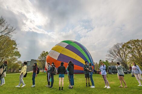 students watch as a hot air balloon is prepped on the Quad