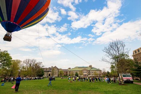 groups of students gather on the Quad with an ice cream truck and a hot air balloon taking flight