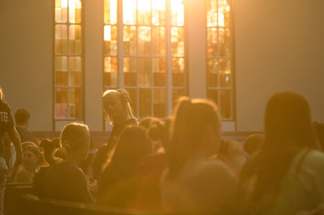 sunlight illuminates students sitting in Colton Chapel