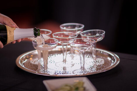 a tray holds several glasses of champagne