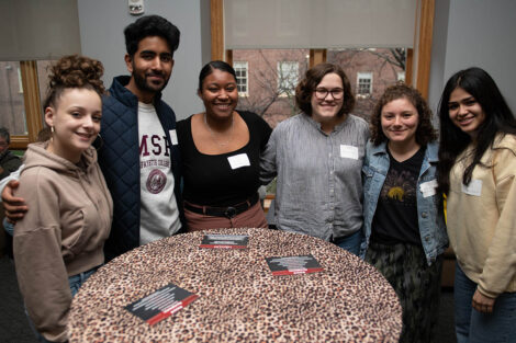 students gather and smile around a table in the Marlo Room