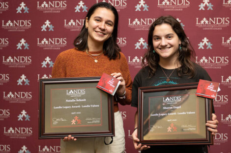 students hold a Landis award in front of a Landis backdrop