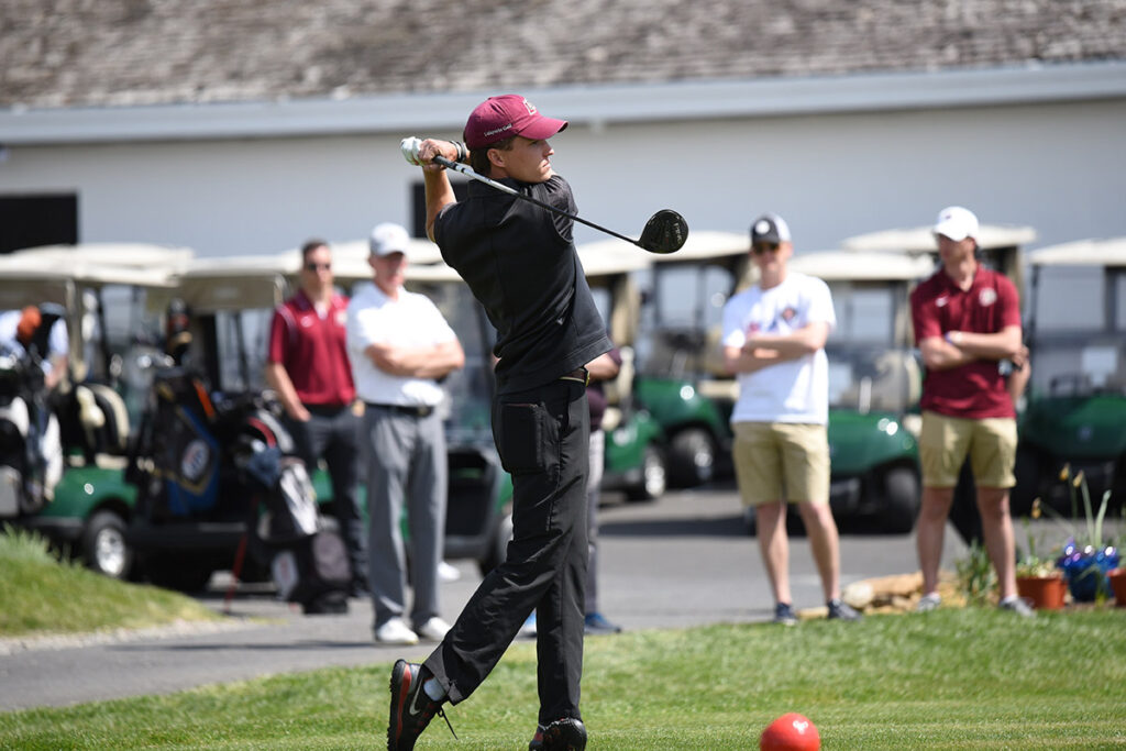 Ryan Tall '24 swings a golf club in competition.