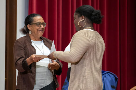 faculty member hands a student a certificate on stage in Colton Chapel