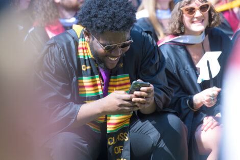 A student smiles on their phone
