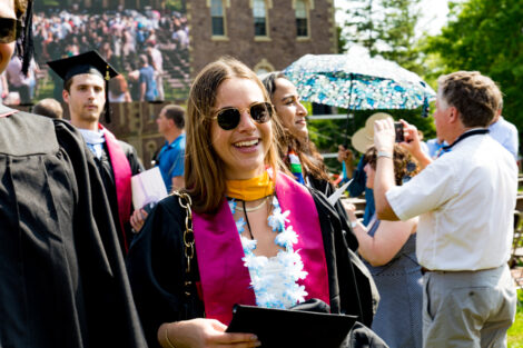 A graduate smiles in sunglasses.