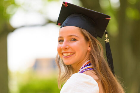 student in graduation cap smiles