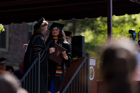 Nicole Hurd presents diploma to student on stage