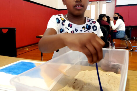 A first-grader from Paxinosa digs for fossils as part of the Connected Classrooms program