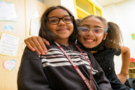 Two female, fourth grade students from Cheston Elementary School participate in Connected Classrooms and smile in their classroom