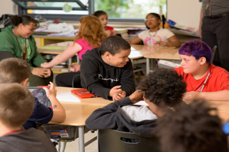 A group of Cheston Elementary fourth graders at their desks, talking to one another, during Connected Classrooms