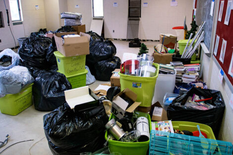 bins and bags filled with donated items sit in a classroom