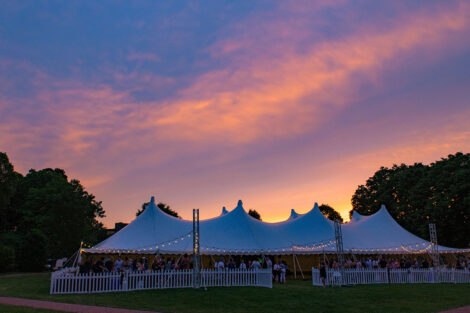 A large white tent on the Quad at sunset.