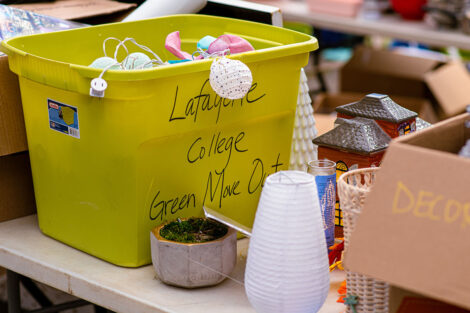 Lafayette College green move out bin sits on a table with other goods
