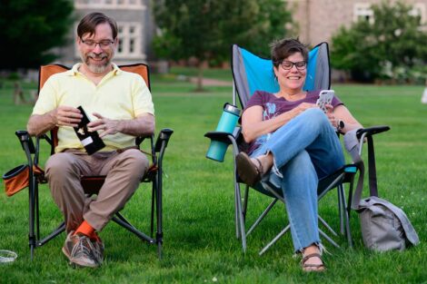 Two Lafayette faculty members sitting on folding chairs on the Quad awaiting the free outdoor movie screening