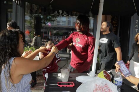 Lafayette College football players surprising Easton residents on the street with Lafayette football jerseys and tickets