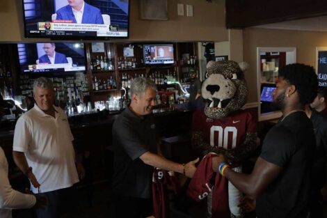 Lafayette College football players handing free football tickets and jerseys to owner of College Hill Tavern in Easton