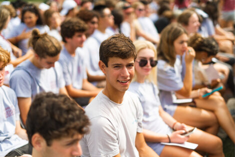 A students smiles in a crowd.
