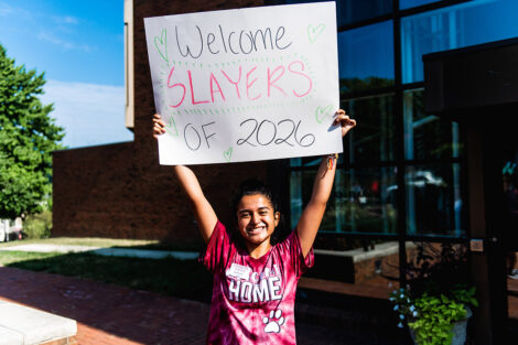 A student holds a sign that reads 