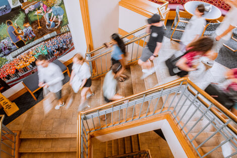 A blur of people walk down the stairs of Farinon.