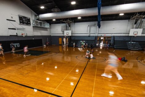 young students run through a gymnasium, a camera effect makes them appear blurred