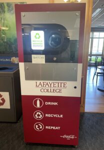 a red and white machine with Lafayette College's logo and recycling icons stands in Farinon