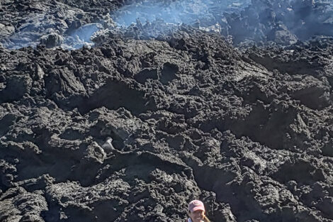 Prof. Tamara Carley standing at the edge of a week-old lava flow