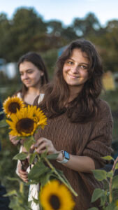 Two students pick sunflowers at LaFarm