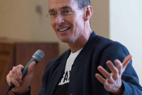 Chip Bergh is smiling and speaking while holding a microphone.