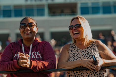 Two women enjoy the Lafayette-Holy Cross Football game during Homecoming.