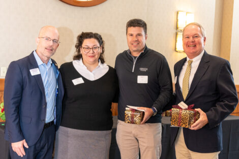 Standing under the medallion of the Marquis de Lafayette, are Mike Summers and Alexis Leon from the Gateway Career Center congratulate , Gat and Alexis Leon, Gateway Career Center; Jacob Ruggles '01 and Judge Richard Hughes '83 P'13. Two of the individuals are holding gifts.