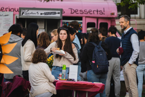 Students eat food from food trucks on the Quad.