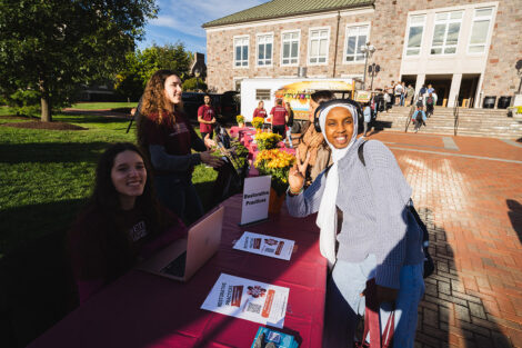 Students smile at a table on the Quad.