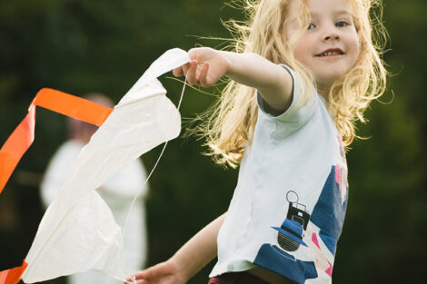 A small child plays with a kite.