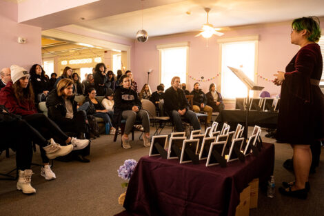 A student speaks to a seated crowd in Lavender Lane.