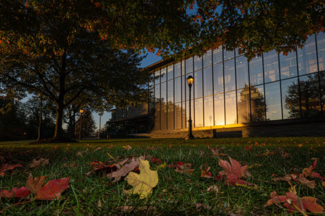 Skillman Library, surrounded by colorful trees and leaves on the grass.