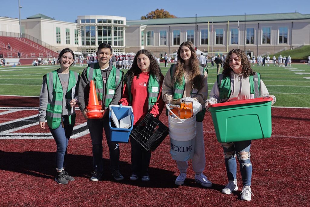 Volunteers carry recycling bins.